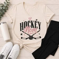 Neutral Hockey Mom V-neck T-shirt featuring crossed hockey sticks, a puck, black stars, and pink heart accents.