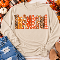 Beige long sleeve crewneck shirt featuring colorful Thankful patchwork lettering in retro autumn floral, plaid and polka dot patterns.