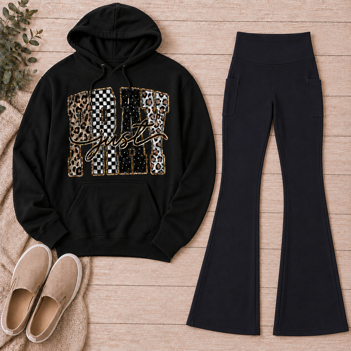 Black Just Pray graphic pullover hoodie with leopard, checkerboard, cow-print, star, and gold accents styled with black pocket flare leggings and beige slip-on shoes.