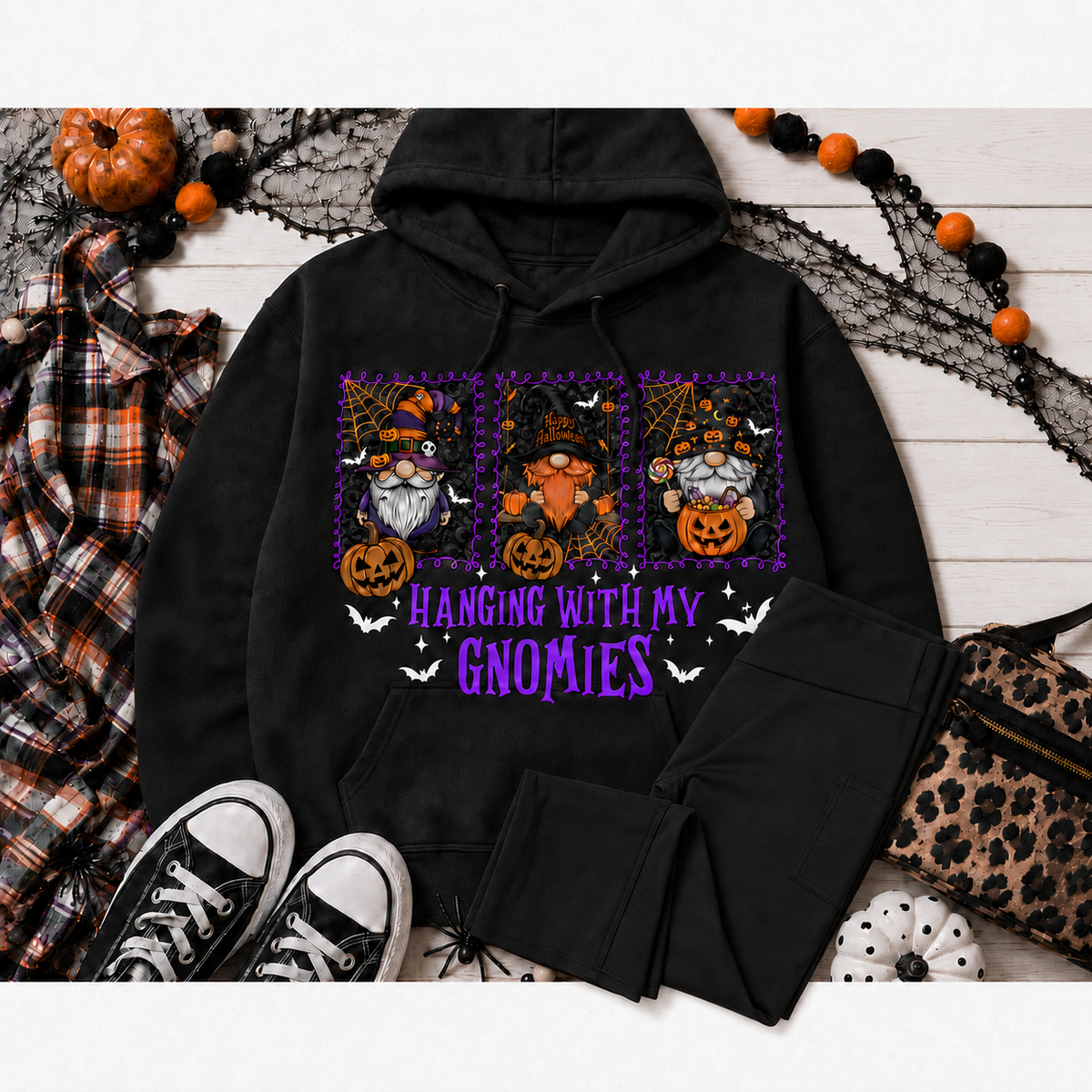 Black Hanging With My Gnomies Halloween pullover hoodie displayed with solid-black bootcut leggings in a festive fall flat lay