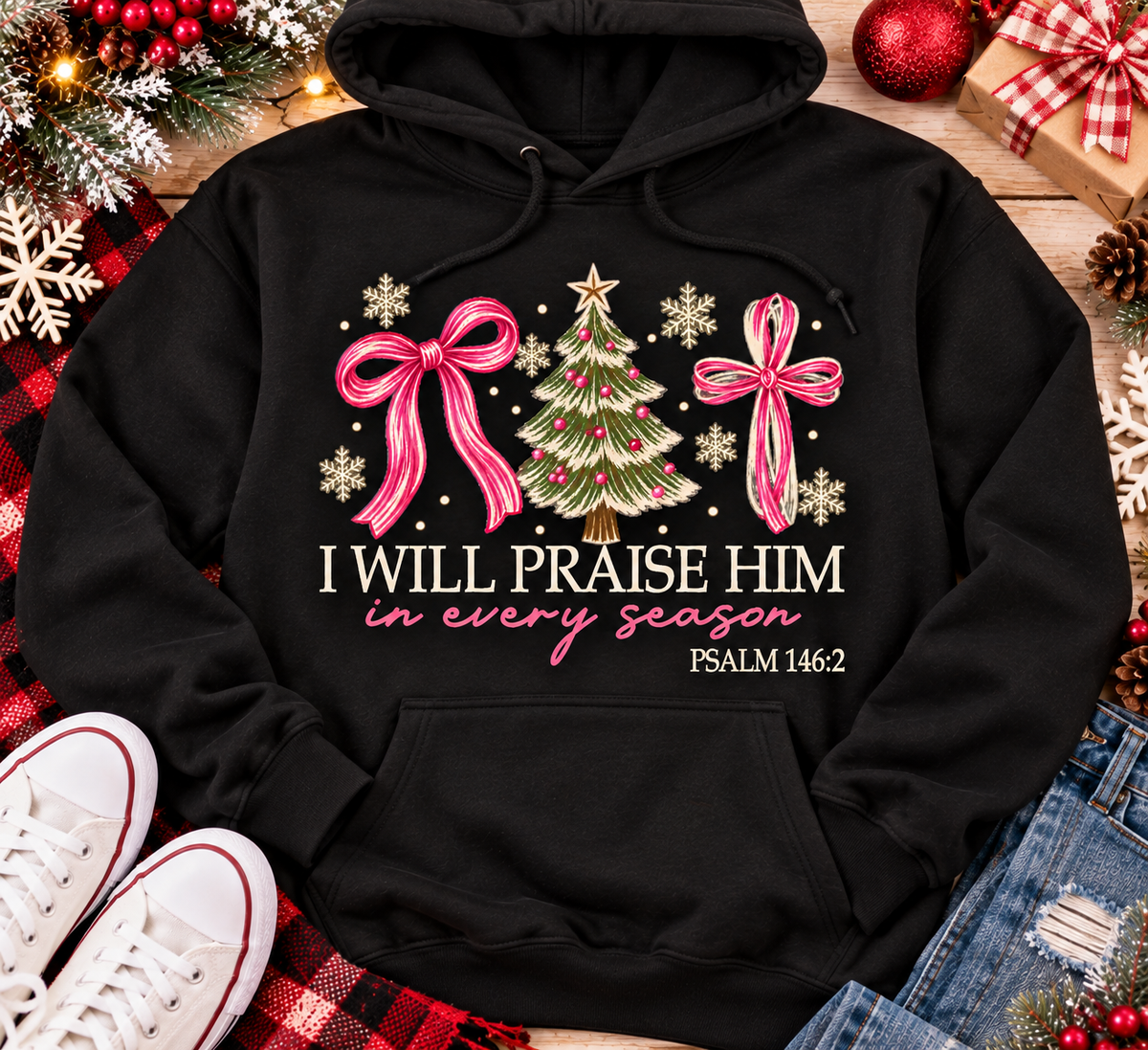 Christian Christmas shirt featuring I Will Praise Him in Every Season Psalm 146:2 graphic with pink bows, decorated Christmas tree, and cream snowflakes.