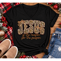 Jesus Is the Reason for the Season Christmas graphic shirt featuring bold leopard print JESUS lettering, decorative gold bows, and gold script. Faith-inspired holiday apparel available in red and black with four style options.