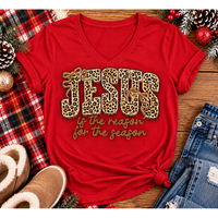 Jesus Is the Reason for the Season Christmas graphic shirt featuring bold leopard print JESUS lettering, decorative gold bows, and gold script. Faith-inspired holiday apparel available in red and black with four style options.
