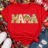 Christmas MAMA graphic shirt featuring pink and green patterned lettering, colorful holiday lights, and a Grinch-inspired character wearing a Santa hat.