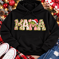 Christmas MAMA graphic shirt featuring pink and green patterned lettering, colorful holiday lights, and a Grinch-inspired character wearing a Santa hat.