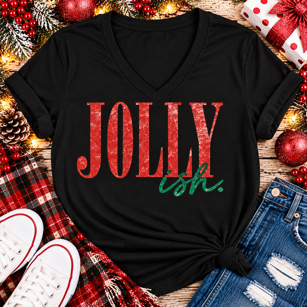 Jolly Ish Christmas graphic shirt featuring large distressed red JOLLY lettering with green handwritten ish script. Funny vintage-inspired holiday apparel available in pink and black, offered in short sleeve crewneck, V-neck, long sleeve and hoodie styles.
