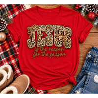 Jesus Is the Reason for the Season Christmas graphic shirt featuring bold leopard print JESUS lettering, decorative gold bows, and gold script. Faith-inspired holiday apparel available in red and black with four style options.