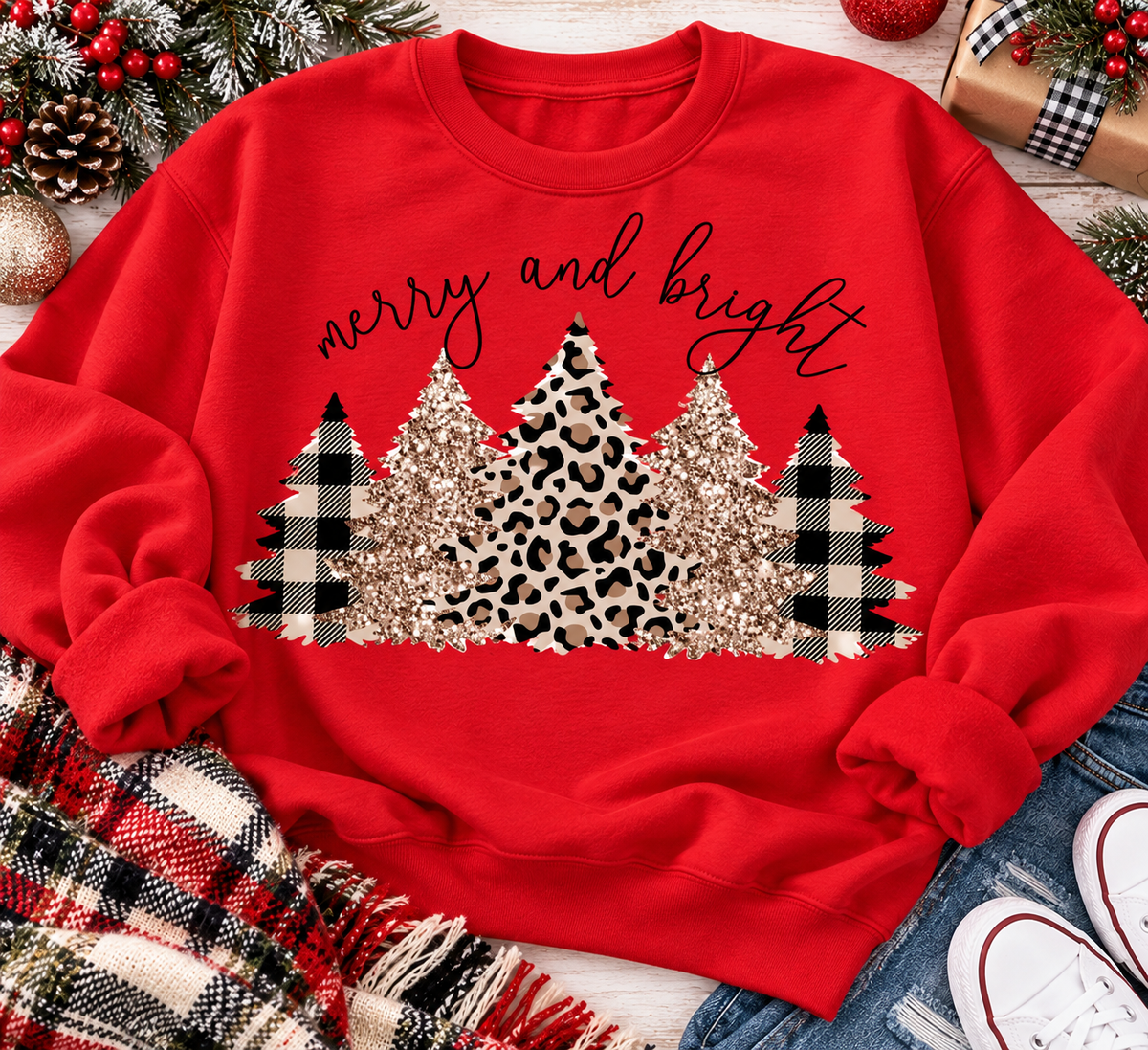 Merry and Bright Christmas graphic apparel featuring leopard print, buffalo plaid and glitter-inspired gold Christmas trees, available in three colors and four styles including crewneck tee, V-neck tee, sweatshirt and hoodie.