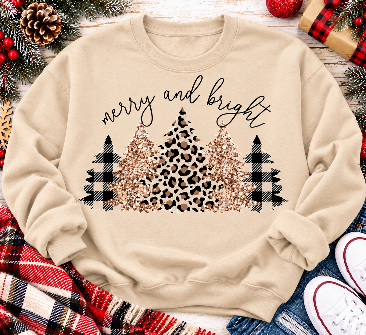 Merry and Bright Christmas graphic apparel featuring leopard print, buffalo plaid and glitter-inspired gold Christmas trees, available in three colors and four styles including crewneck tee, V-neck tee, sweatshirt and hoodie.