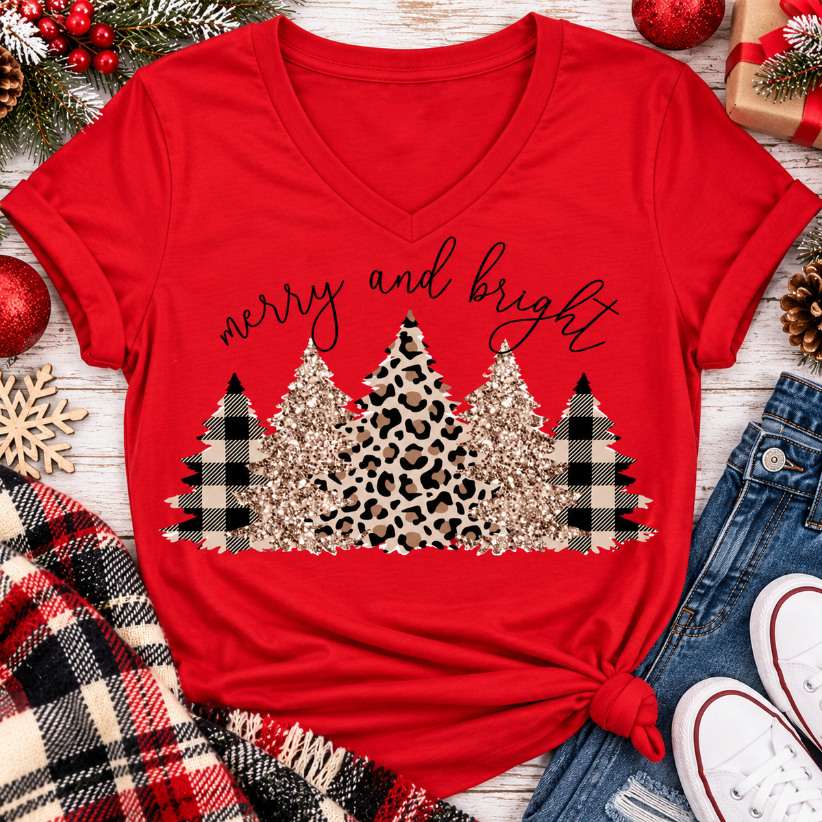 Merry and Bright Christmas graphic apparel featuring leopard print, buffalo plaid and glitter-inspired gold Christmas trees, available in three colors and four styles including crewneck tee, V-neck tee, sweatshirt and hoodie.