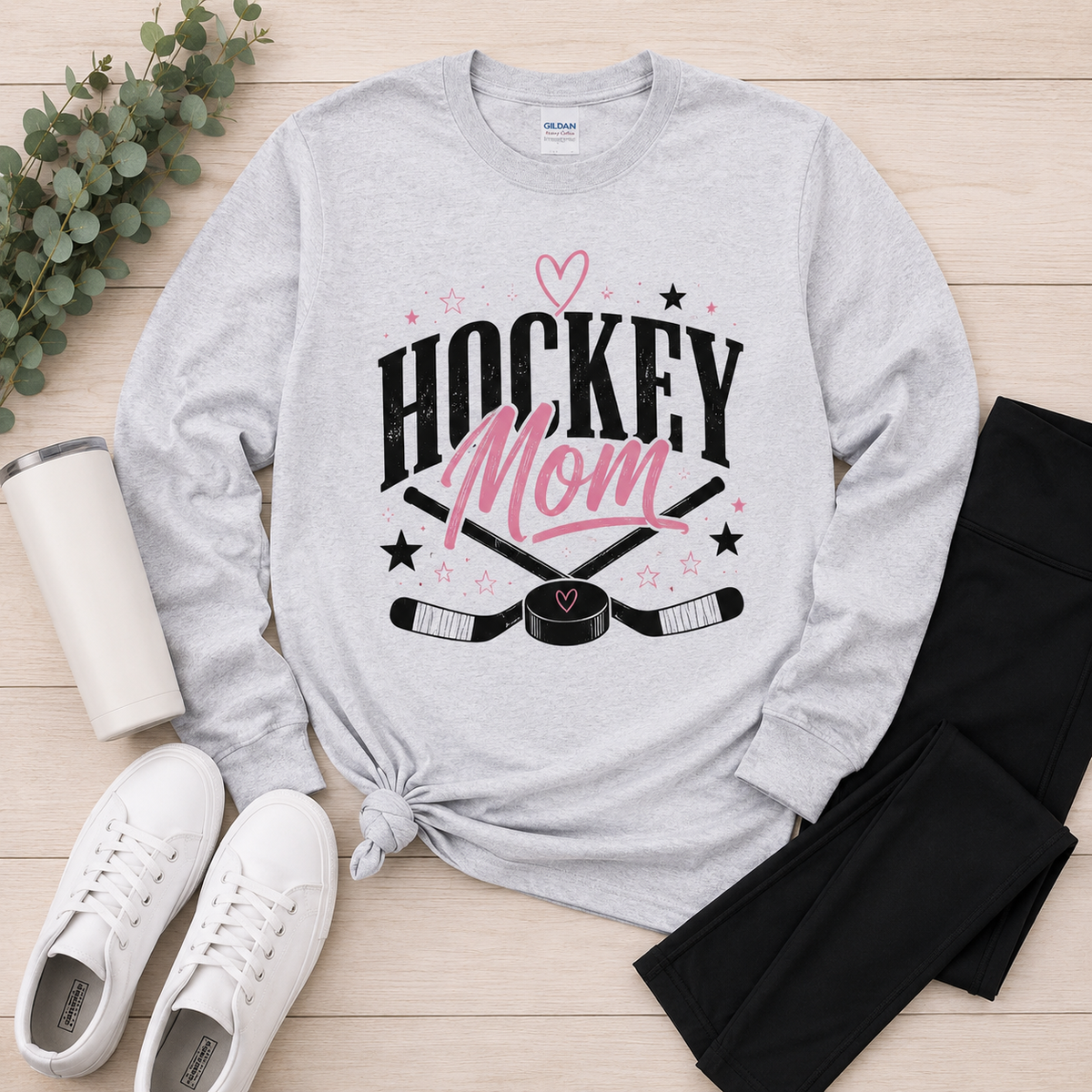 Heather gray long sleeve Hockey Mom graphic tee featuring a black and pink hockey design styled with black leggings and white sneakers.