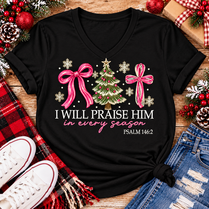 Christian Christmas shirt featuring I Will Praise Him in Every Season Psalm 146:2 graphic with pink bows, decorated Christmas tree, and cream snowflakes.