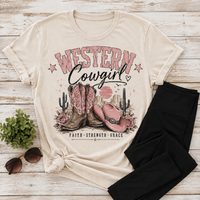 Cream V-neck Western Cowgirl graphic tee featuring pink cowboy boots, pink cowgirl hat, roses, cacti, desert sunset and Faith Strength Grace text.