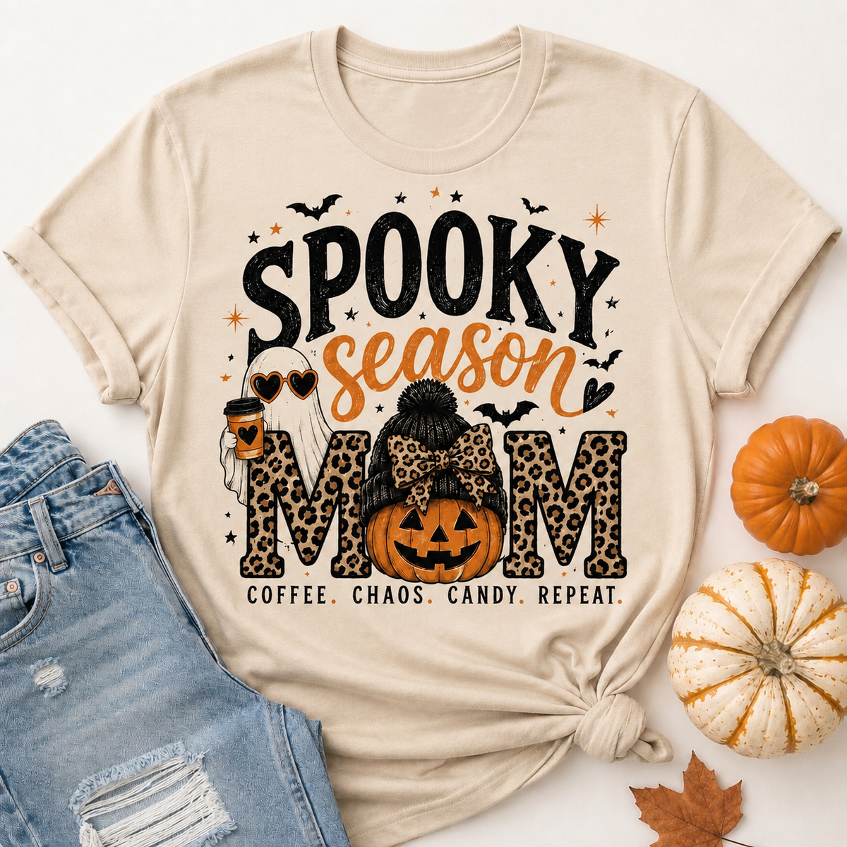 Beige Spooky Season Mom graphic tee featuring leopard print lettering, coffee ghost, jack-o'-lantern pumpkin, bats and Coffee Chaos Candy Repeat text.