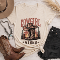 Cowgirl Vibes western graphic apparel featuring cowboy boots, cowgirl hat, cacti and desert sunset design